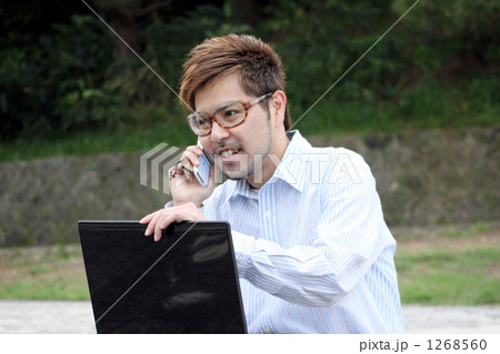 髭 茶髪 携帯電話 ワイシャツの写真素材