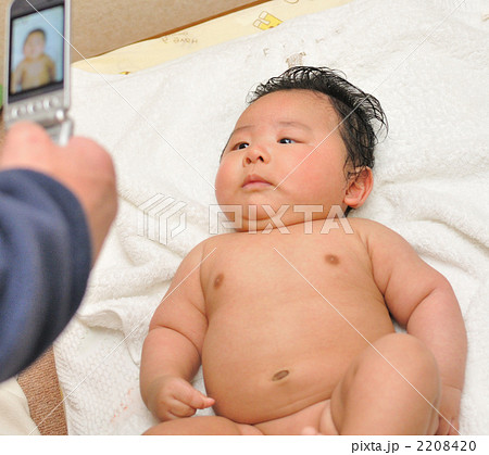 赤ちゃん 裸 携帯電話 生後３ヶ月の写真素材