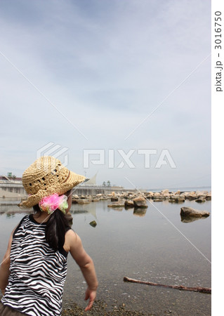 赤ちゃん 1人 後姿 石投げの写真素材