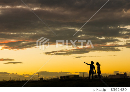 シルエット 土手 10月 二人の写真素材
