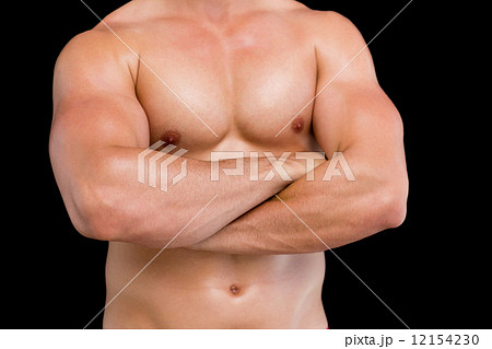 Portrait of shirtless muscular man standing with arms crossed