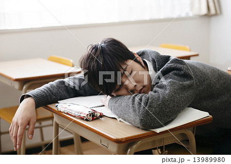 授業中に居眠りをする男子学生の写真素材