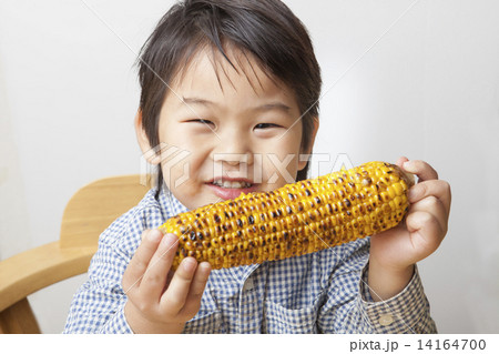 焼きとうもろこし 男の子 子供 食べるの写真素材
