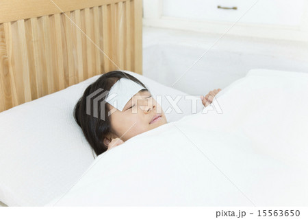 体調不良 寝る 女の子 熱の写真素材