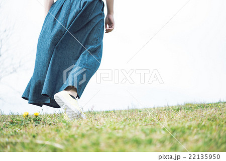 女性 丘 歩く ロングスカートの写真素材