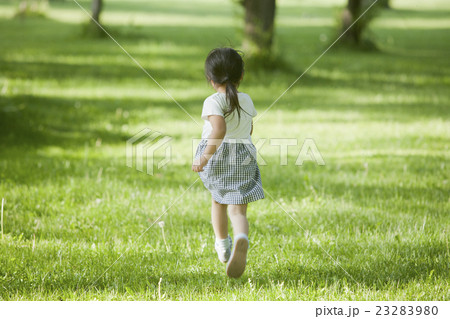 子供 女の子 走る 後姿の写真素材
