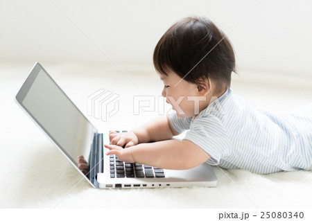 赤ちゃん ノートパソコン 興味 触るの写真素材