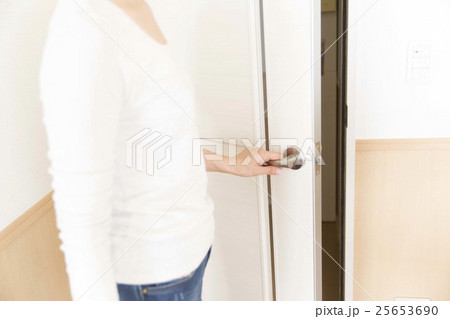 女性 ドア 後姿 開けるの写真素材