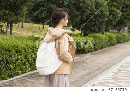女性 リュックサック 背負う 後姿の写真素材