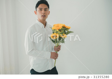 ひまわり 男性 花束 持つの写真素材