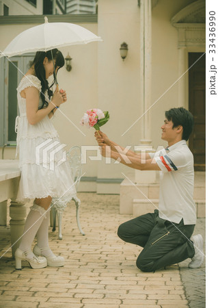 プロポーズ 花束 ひざまずく 男の写真素材