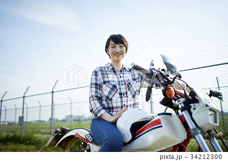 人物 女性 バイク またがるの写真素材