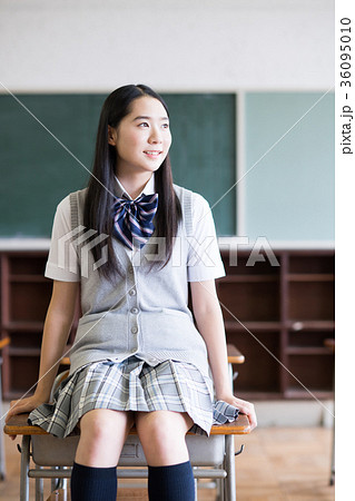 女子高生 教室 制服 座るの写真素材