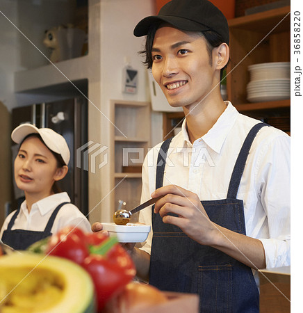 女性 エプロン カフェ店員 キャップの写真素材