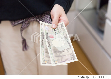 現金 渡す 1万円札 手元の写真素材
