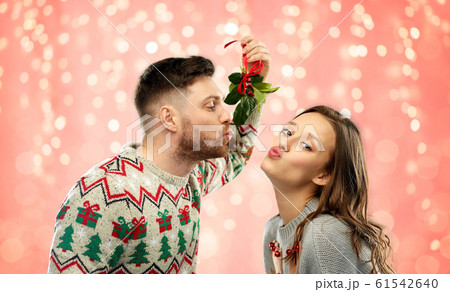 クリスマス カップル キス ヤドリギの写真素材