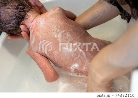 赤ちゃん 沐浴 新生児 背中の写真素材