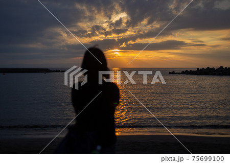 後ろ姿 女性 夕日 海の写真素材