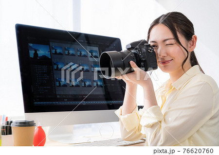 女性 覗く 構える カメラの写真素材