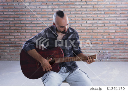 ギター 演奏 座る シャツの写真素材