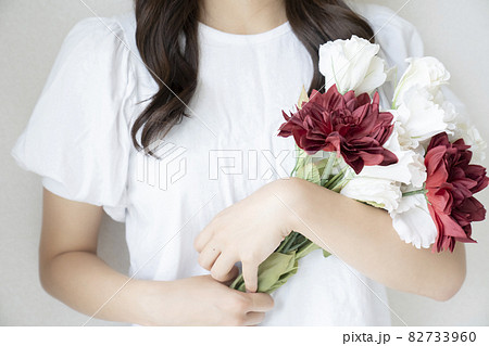 女性 花束 抱える 花の写真素材