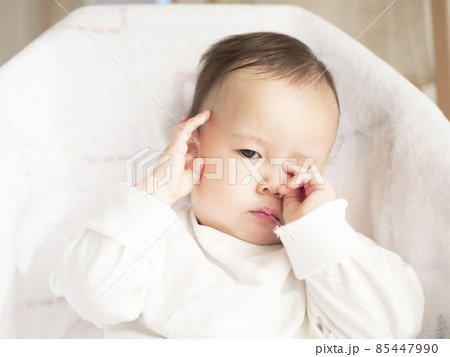 赤ちゃん 子供 目をこする 不機嫌の写真素材