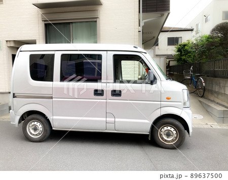 宅配便を住宅街で配送中の軽バン