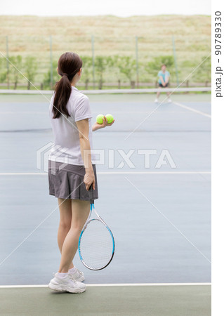 人物 女性 後姿 テニス サーブの写真素材