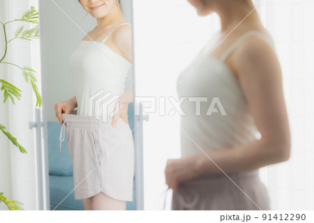 Shot of beautiful slim body of woman in white lingerie on beige